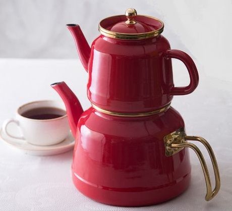 a red coffee pot and cup on a white table