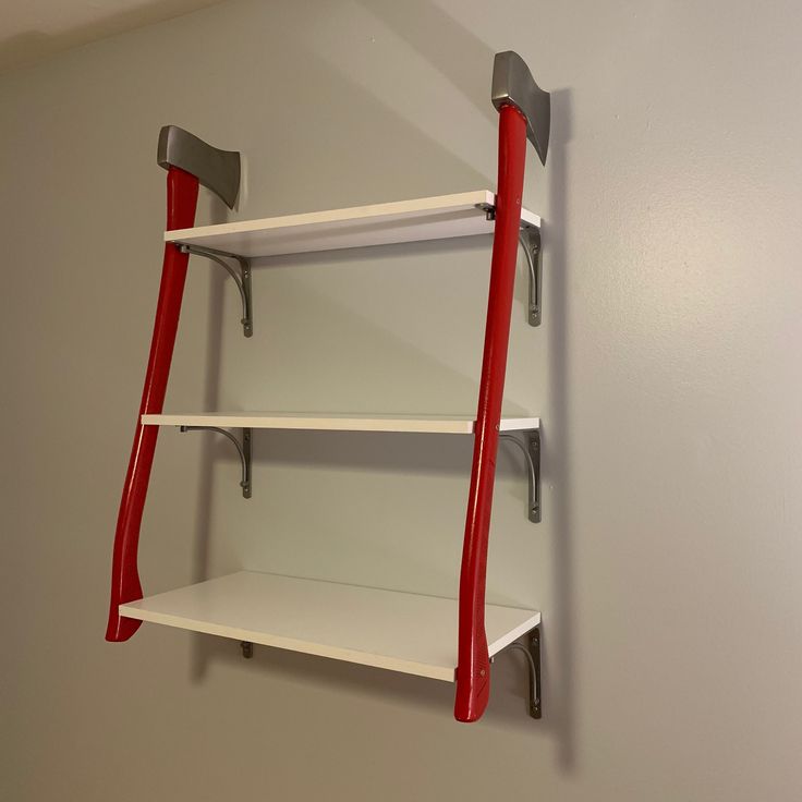 a red and white shelf on the wall next to a gray wall with two shelves