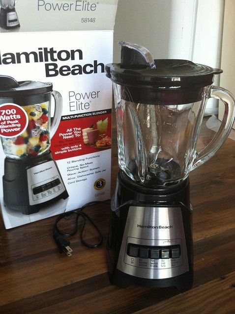 a blender sitting on top of a wooden table next to a power lite box