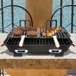 an outdoor grill with hamburgers and other food on it next to a body of water