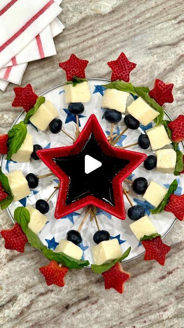 a plate topped with fruit and cheese on top of a wooden table next to an american flag napkin