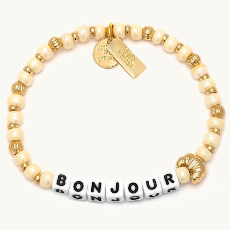 As Emily would say, A little ‘bonjour’ goes a long way". Channel her cheerful personality with the return of our beloved “Bonjour” bracelet featuring a quintessentially Parisian croissant casted bead. Add a touch of Parisian charm to your style and make every day more magnifique Parisian Croissant, Hostess Snacks, Little Words Project, Swimsuit Jewelry, Paris Bracelet, Drinking Accessories, Vacay Outfits, Project X, Jeweled Earrings