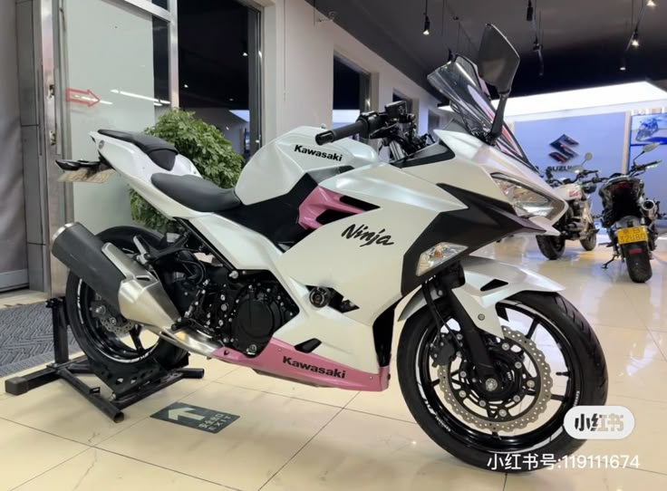 a white and pink motorcycle on display in a showroom