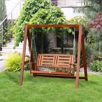 a wooden swing in the middle of some grass