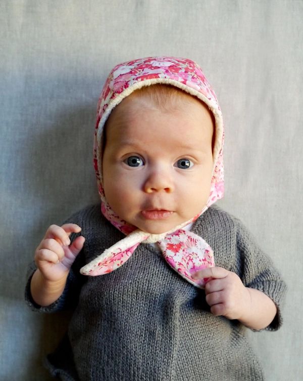 a baby wearing a pink hat and scarf