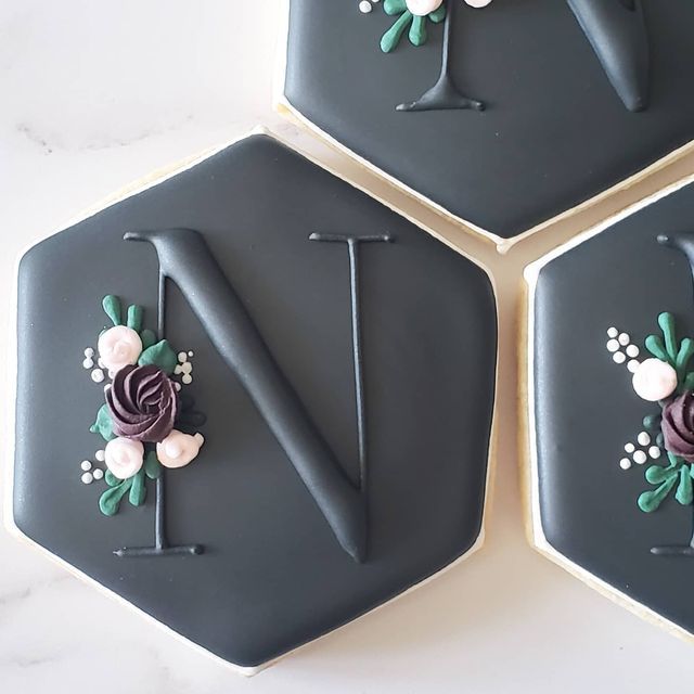 three decorated cookies are arranged in the shape of hexagons with flowers on them