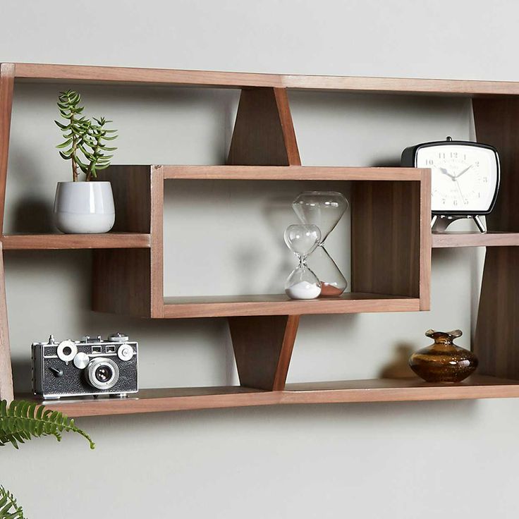 a wooden shelf with various items on it and a plant in the corner next to it