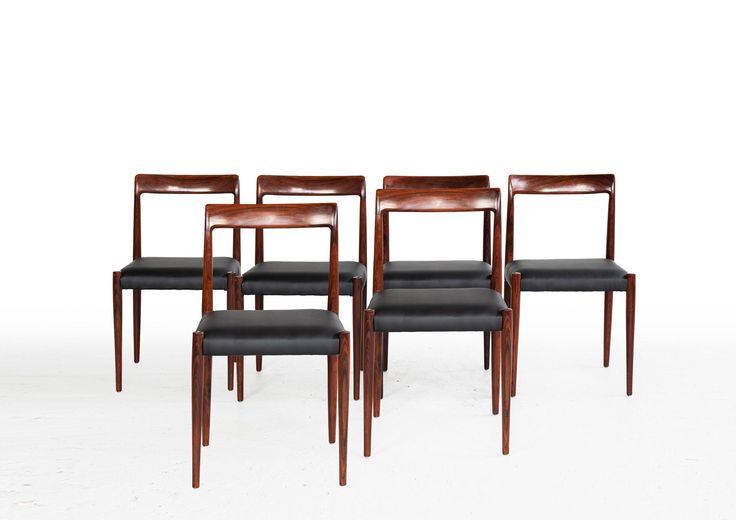 four chairs with black leather upholstered back and seat cushions are shown in front of a white background