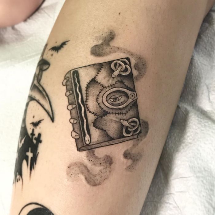 a black and white photo of a tattoo on someone's leg