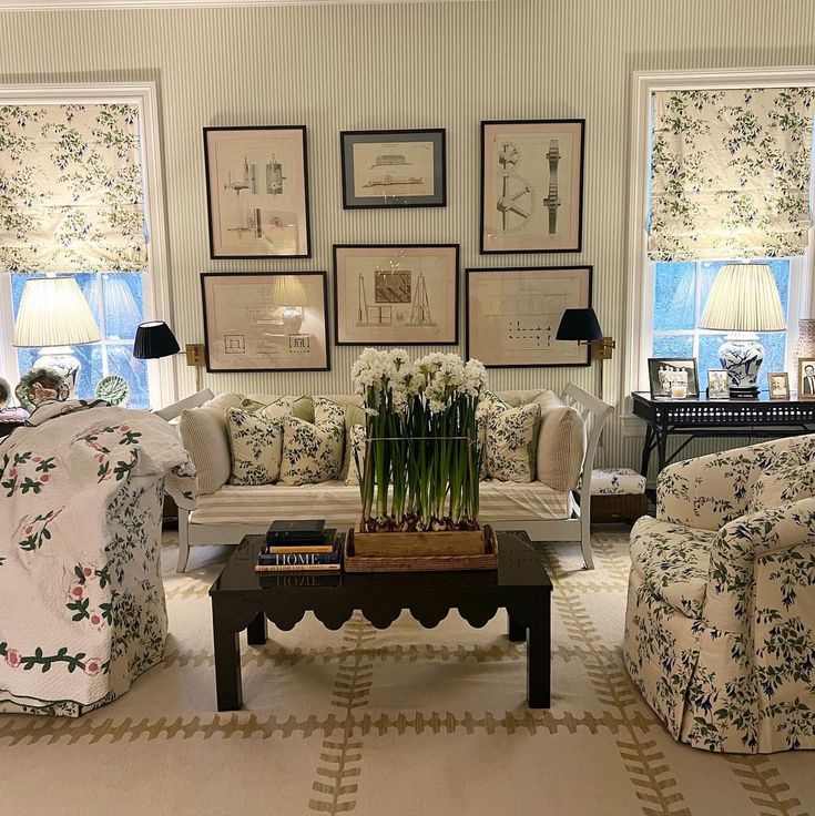 a living room with couches, chairs and pictures on the wall in it's center