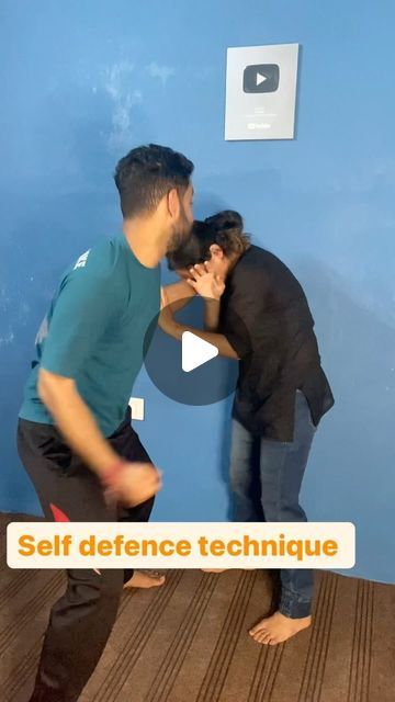 two men standing in front of a blue wall with the words self defence technique written on it