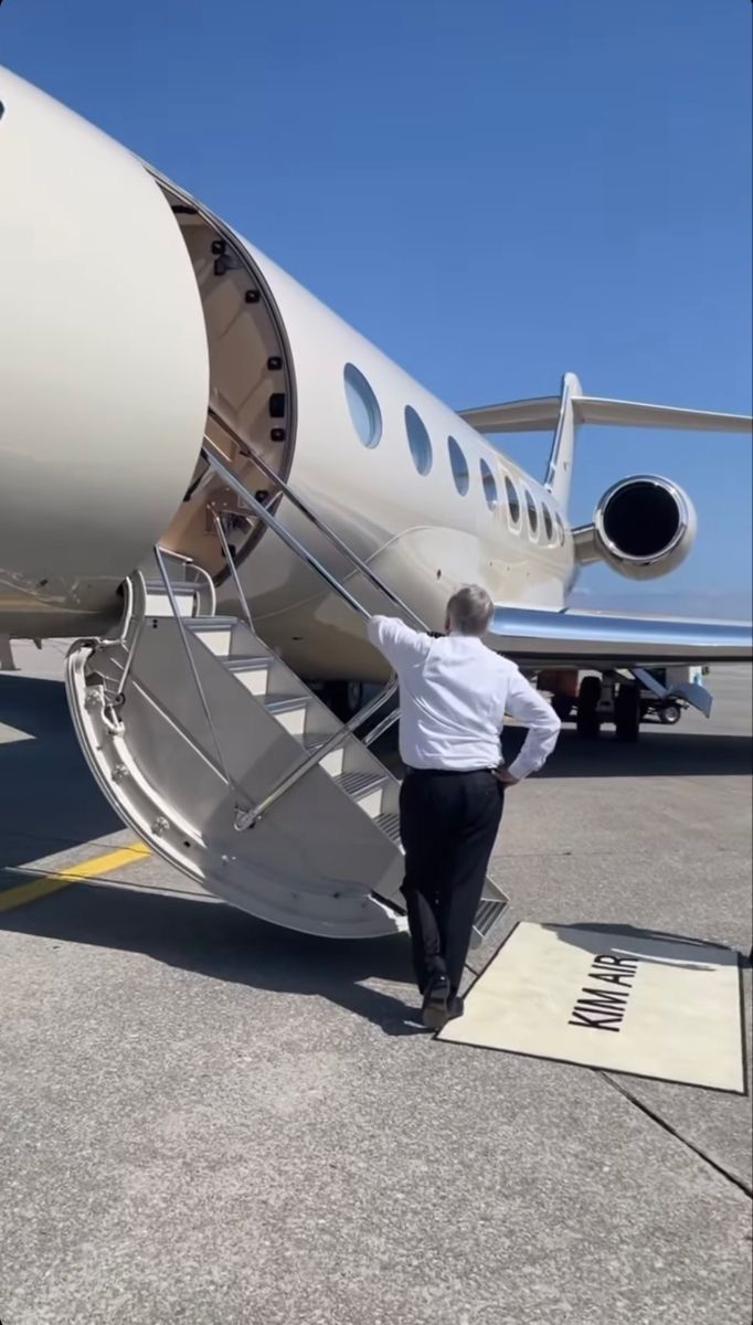 a man stepping off the stairs of an airplane