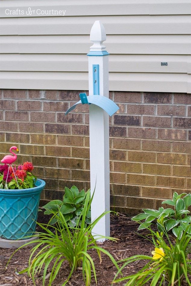 a blue and white birdhouse next to some flowers