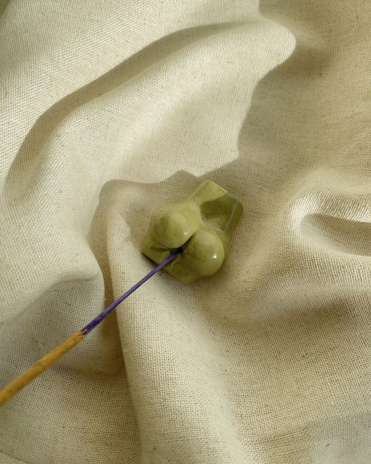 a needle is laying on top of a white cloth with an object in the middle