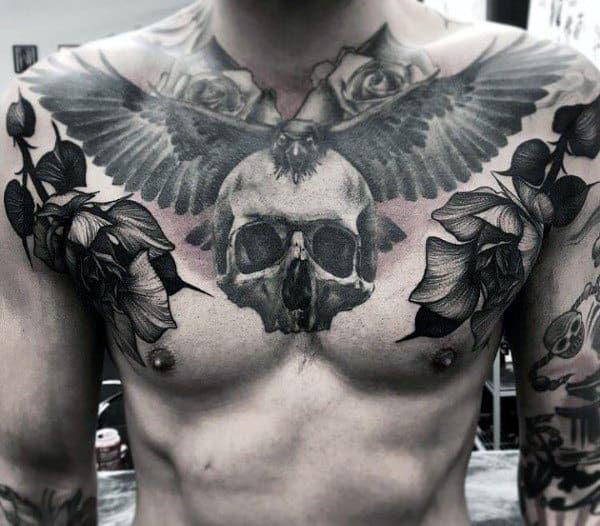 a man with tattoos on his chest has a skull and flowers in the middle of it