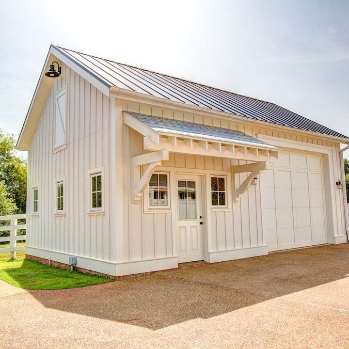 a small white house with a metal roof and sun shining through the windows on top