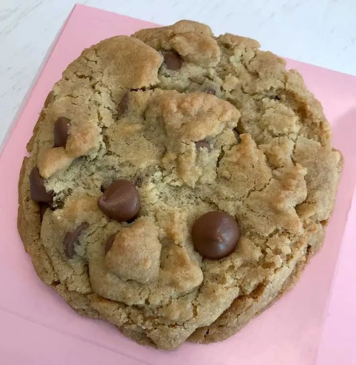 a chocolate chip cookie sitting on top of a pink napkin