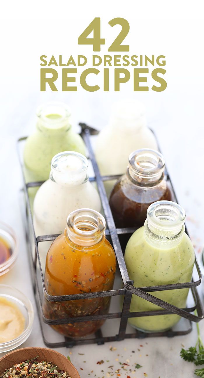 salad dressing recipe in small glass containers on a table with herbs and sauces next to it