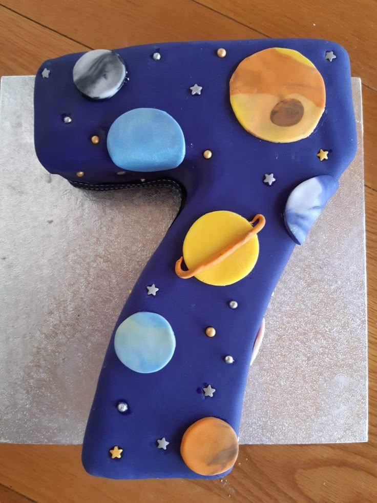 the number seven cake is made to look like an outer space theme