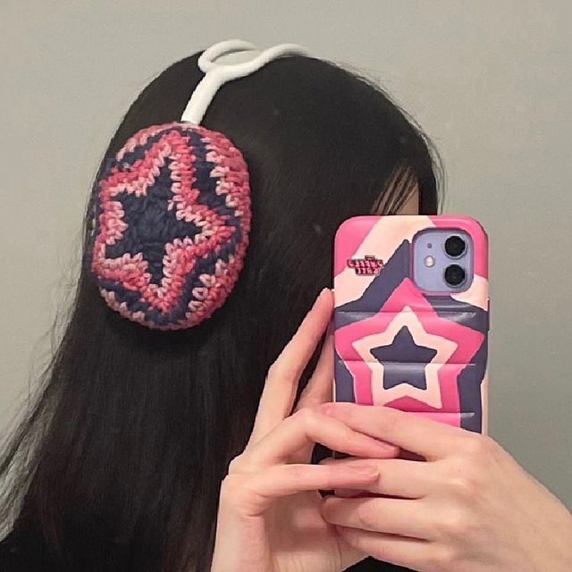 a woman is taking a selfie with her cell phone and hair clip in front of her