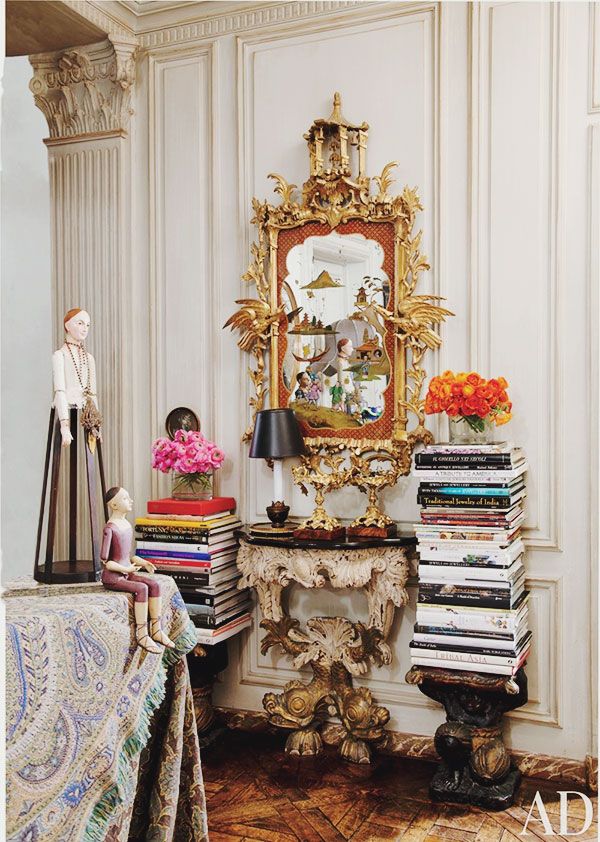 a living room filled with lots of furniture and a large mirror on top of a table