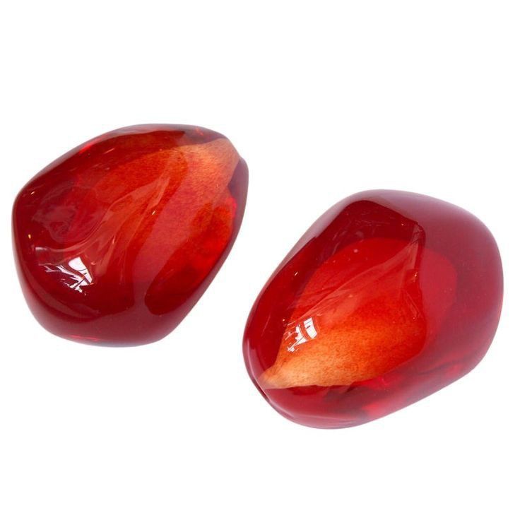 two red stones sitting next to each other on a white surface