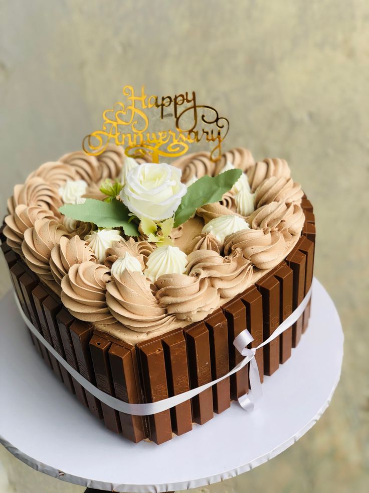 a heart shaped chocolate cake with white flowers on top