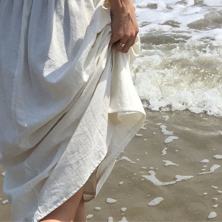 a person standing on the beach with their feet in the water