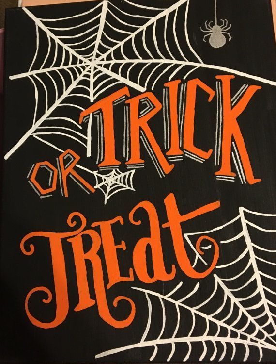 a trick or treat sign with spider webs and orange lettering on black paper that says trick or treat