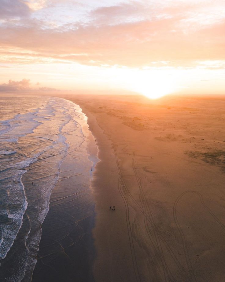 an aerial view of the beach at sunset