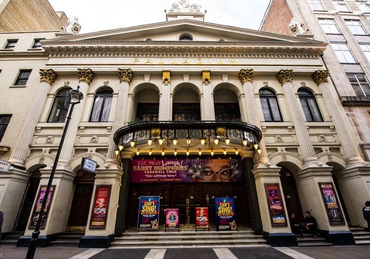 an old theater building with the front entrance lit up