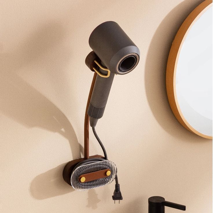 a hair dryer is hanging on the wall next to a mirror