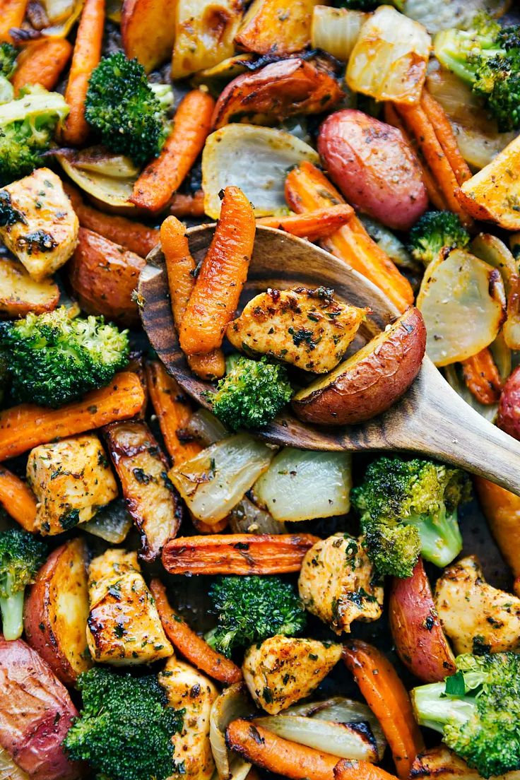 a mixture of vegetables including carrots, broccoli and cauliflower with a wooden spoon