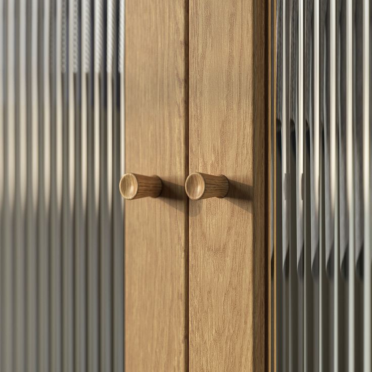 a close up of a wooden cabinet with metal pipes on the wall in the background