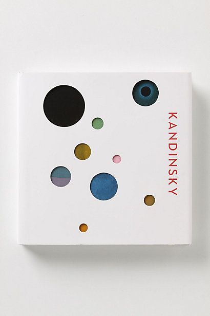 a book with different colored dots on the front and back cover, sitting on a white surface