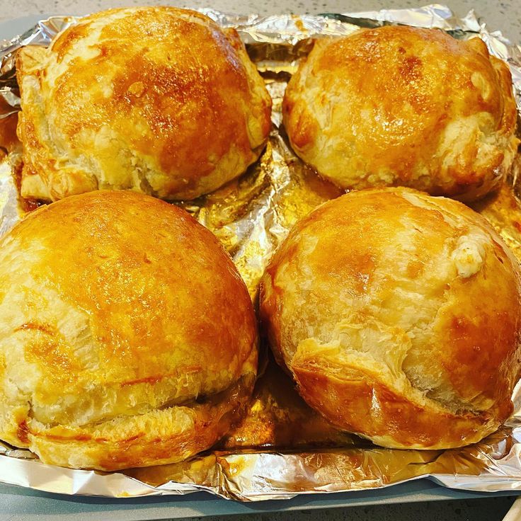 several baked pastries sitting on top of tin foil