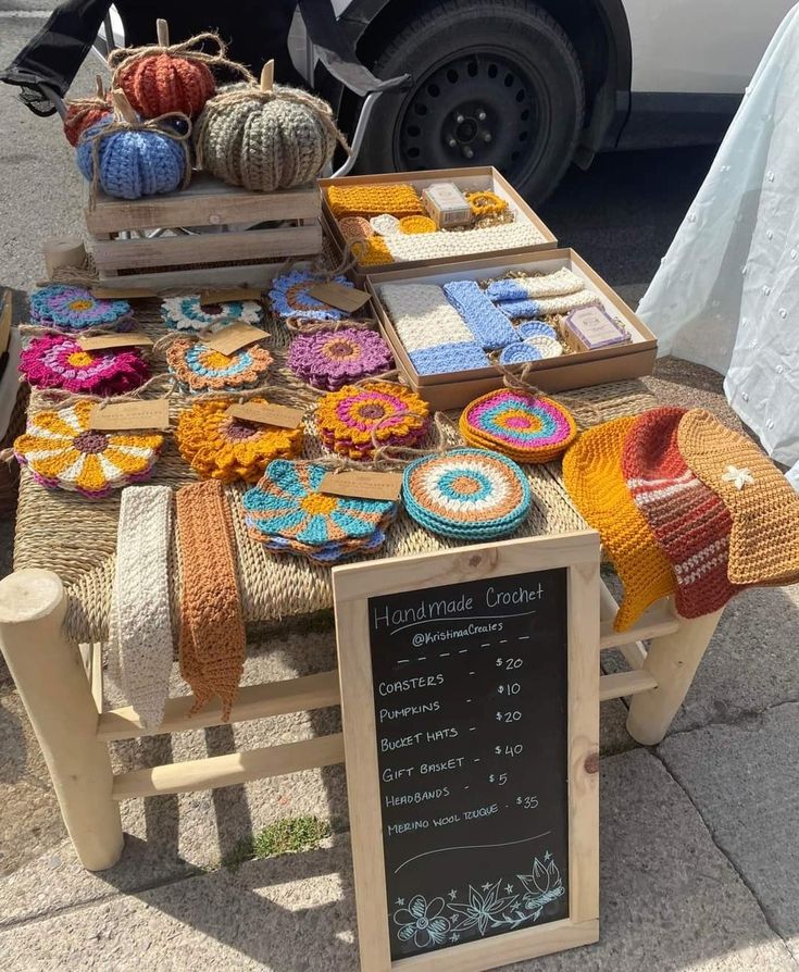 the table is covered with crocheted items for sale