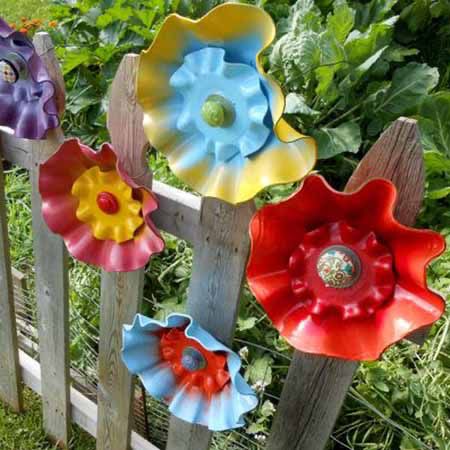 four colorful flower sculptures are sitting on the fence