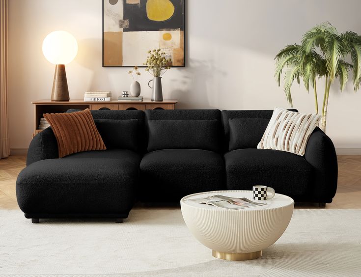 a living room with a large black couch and white rugs on the floor next to a coffee table