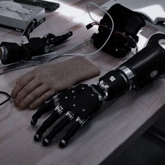 a robotic hand sitting on top of a wooden table