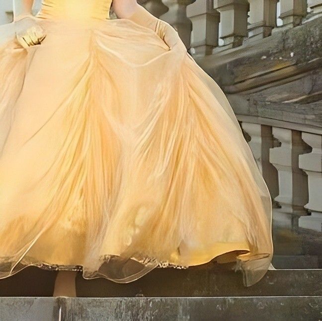 a woman in a yellow dress standing on some steps