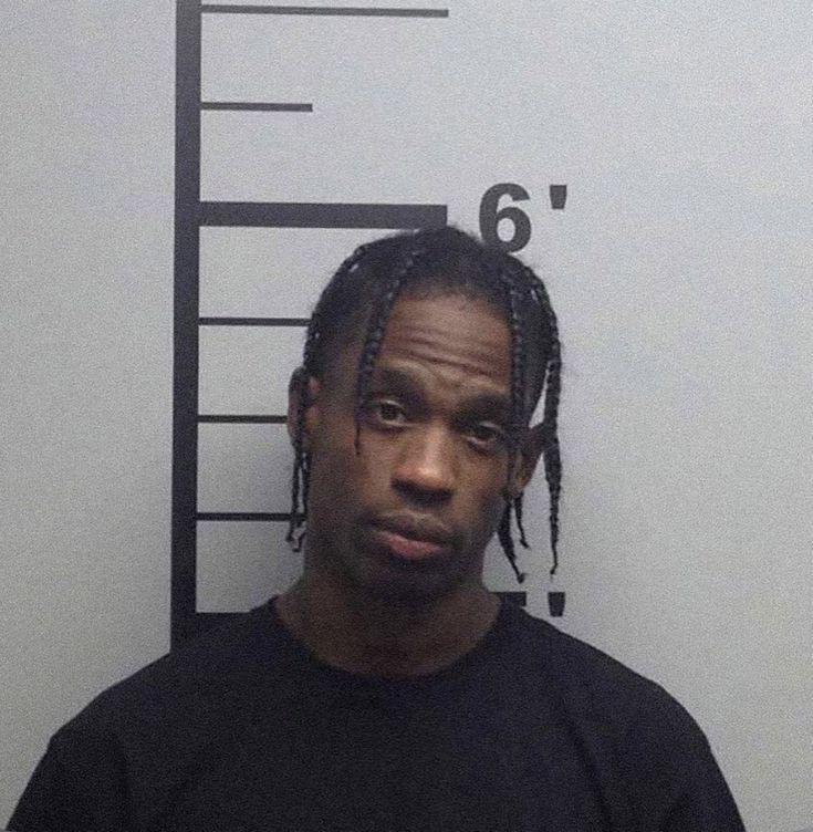 a man with dreadlocks standing in front of a mug shot