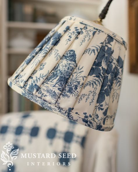 a blue and white lamp shade hanging from a ceiling fixture in a living room or dining room