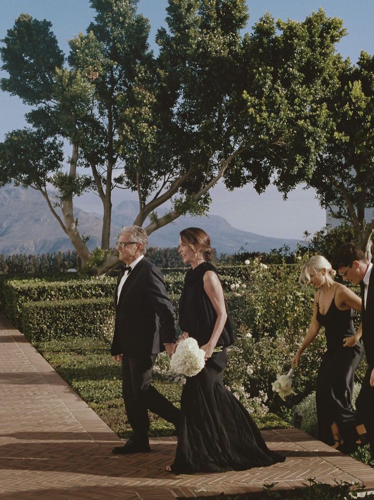 two men and a woman walking down a path