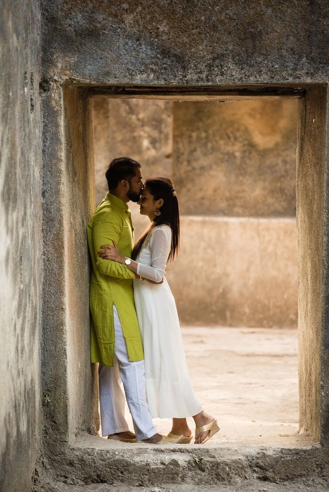 a man and woman standing next to each other in an open doorway with their arms around each other