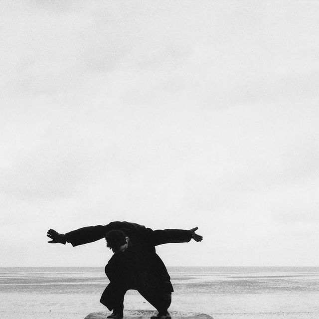 a man standing on top of a rock near the ocean