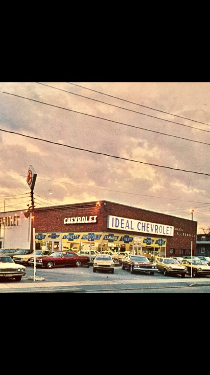 an old photo of the outside of a chevrolet dealership with cars parked in front