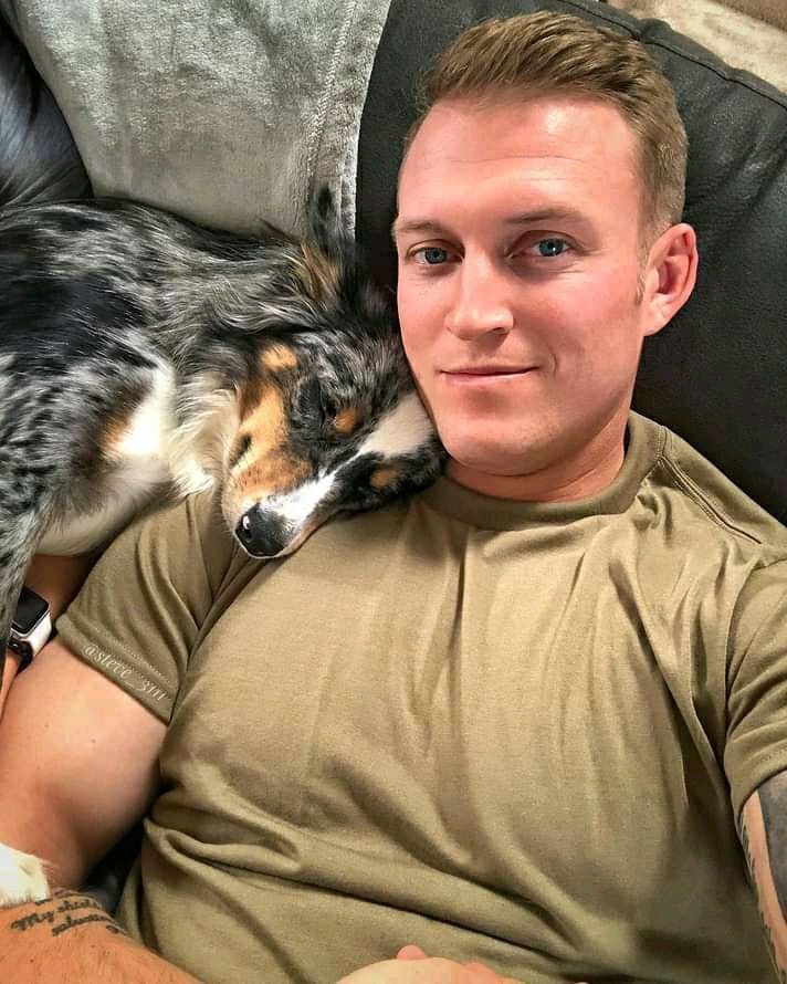 a man laying on top of a couch next to a dog