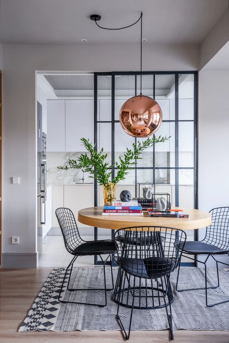 a dining room table with chairs and a potted plant