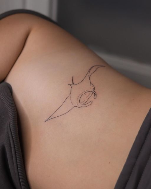 a woman's stomach with a small tattoo on her left side shoulder and an animal head in the middle